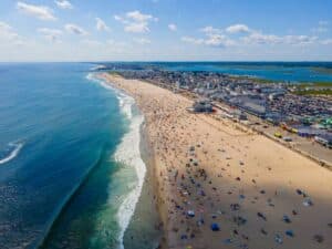 Aerial view of a busy Hampton Beach, where you'll find Hampton Beach State Park and so many more great things to do.