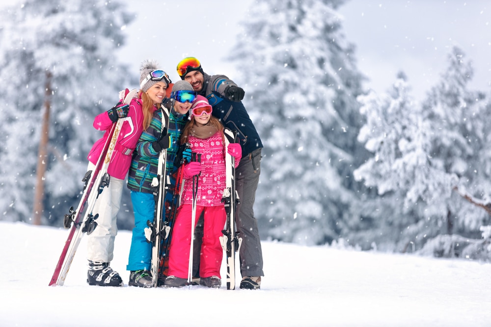 A family poses for a picture on a ski hill near one of the best family-friendly hotels in Exeter, NH.