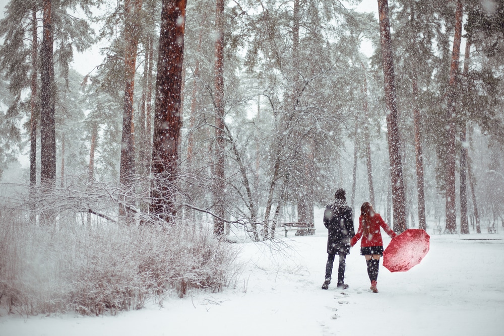 Lovers stroll through the snow on a couples getaway in New Hampshire.