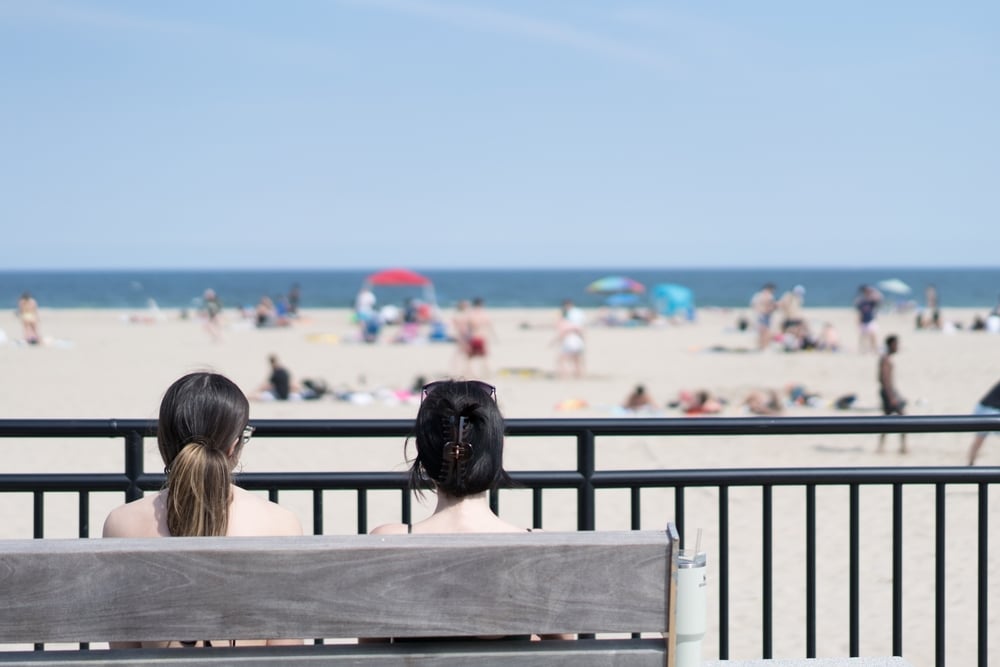 Why You Should Visit the Hampton Beach Boardwalk 4 Two women sitting on a bench overlooking Hampton Beach on the New Hampshire Seacoast