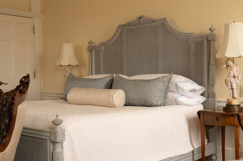 The Best Romantic New Hampshire Getaways 8 Stay at one of the best hotels in Exeter New Hampshire. Bed, with cream white bedspread and gray headboard.