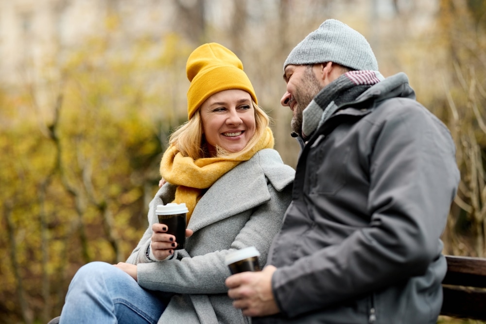 Exeter, one of the best towns in New Hampshire, is the perfect place to reconnect with your loved one. Two people enjoying a hot drink and each other's company on a bench.